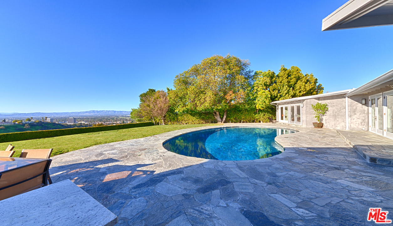 3921 Cody Road Sherman Oaks, CA 91403 - Photo 22 of 36 a view of a swimming pool with an outdoor space and seating area