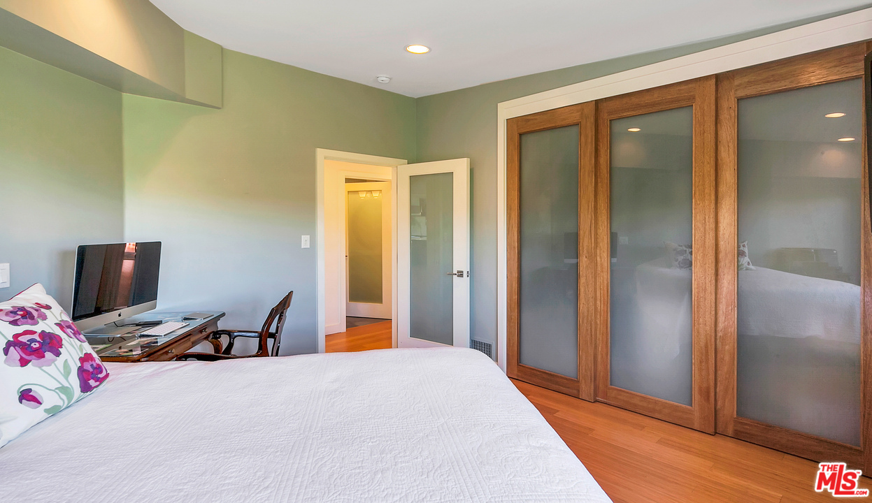 3921 Cody Road Sherman Oaks, CA 91403 - Photo 30 of 36 a bedroom with a bed and wooden floor