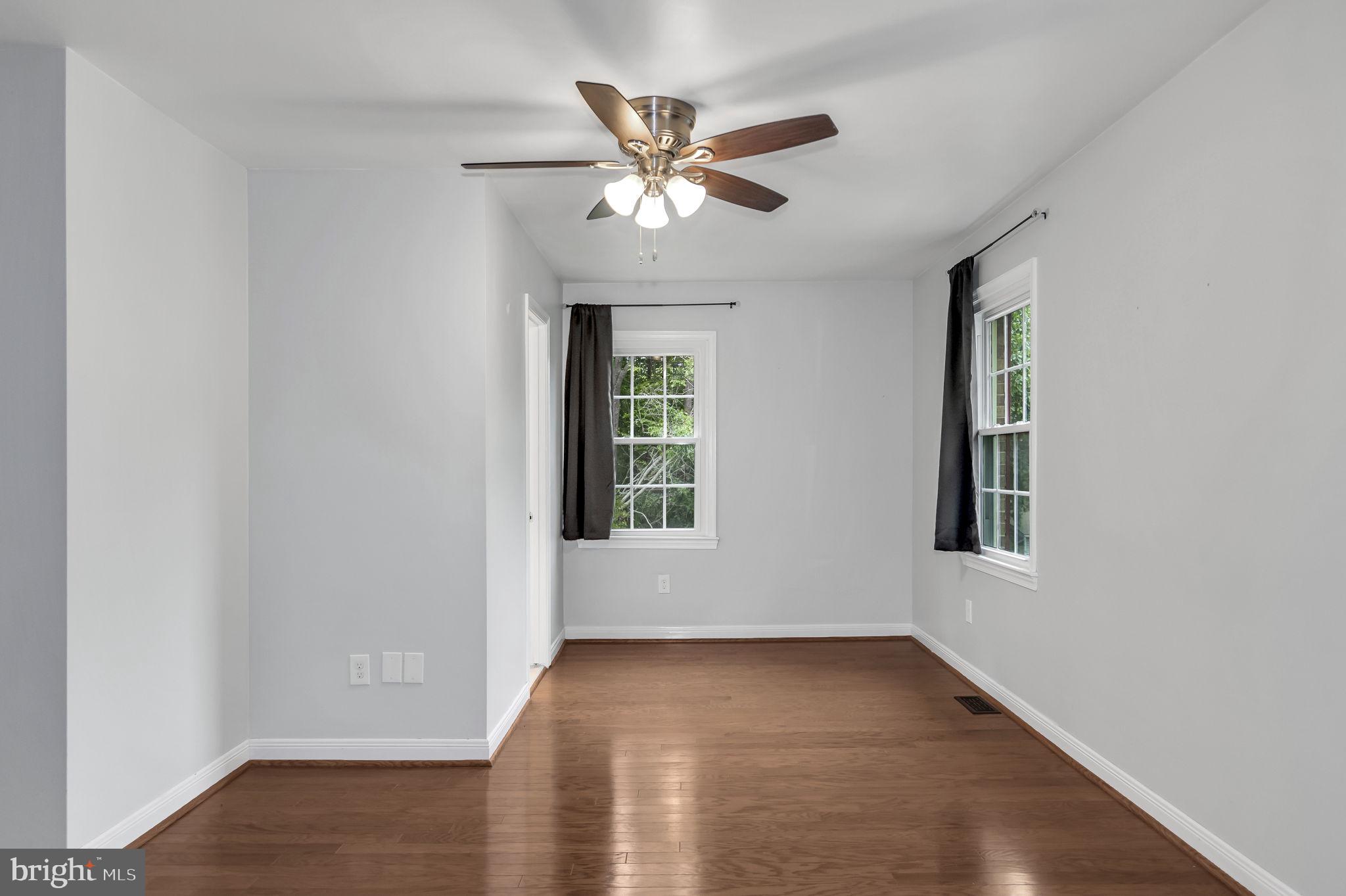 8914 Grandstaff Court Springfield, VA 22153 - Photo 16 of 48 an empty room with wooden floor chandelier fan and windows