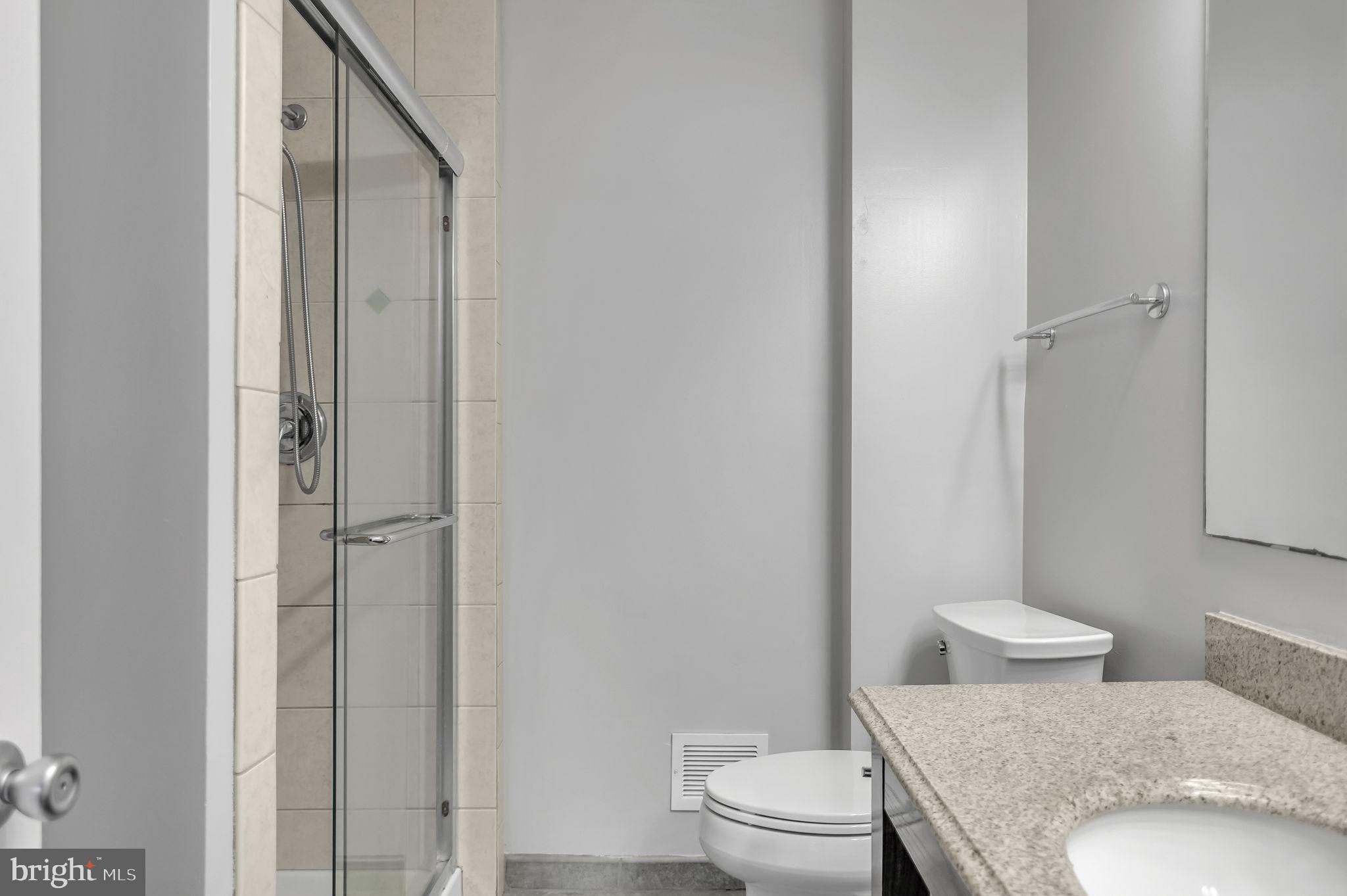8914 Grandstaff Court Springfield, VA 22153 - Photo 19 of 48 a bathroom with a granite countertop toilet a sink and a mirror
