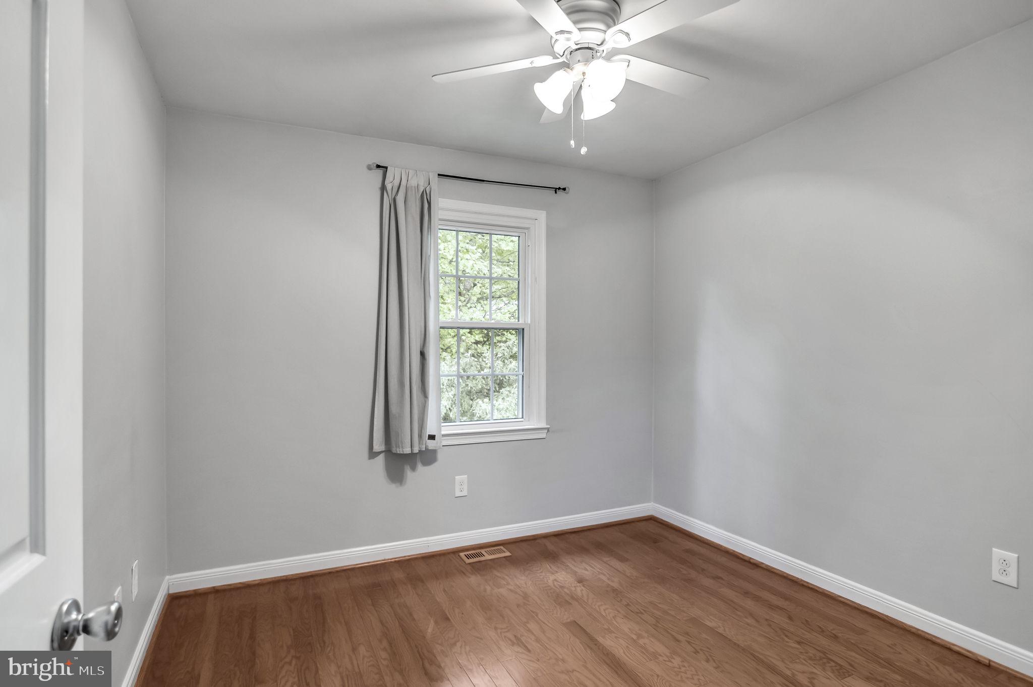 8914 Grandstaff Court Springfield, VA 22153 - Photo 24 of 48 an empty room with wooden floor chandelier fan and windows