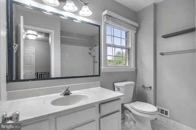 a bathroom with a toilet a sink and a mirror