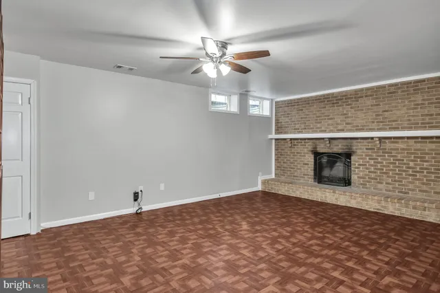 en empty room with a ceiling fan and a fireplace