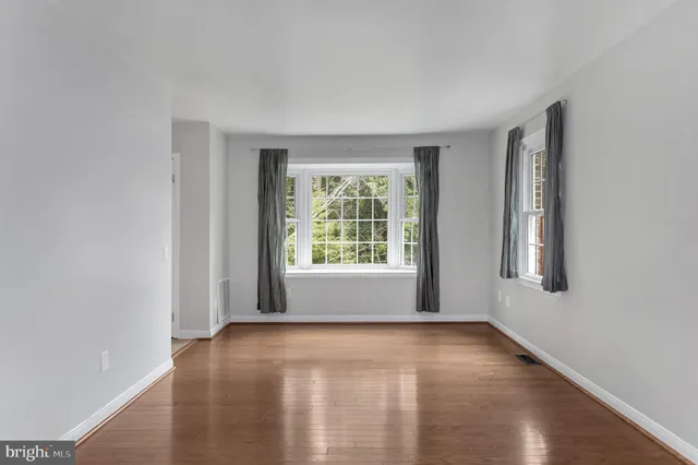 a view of an empty room with glass window and closet area