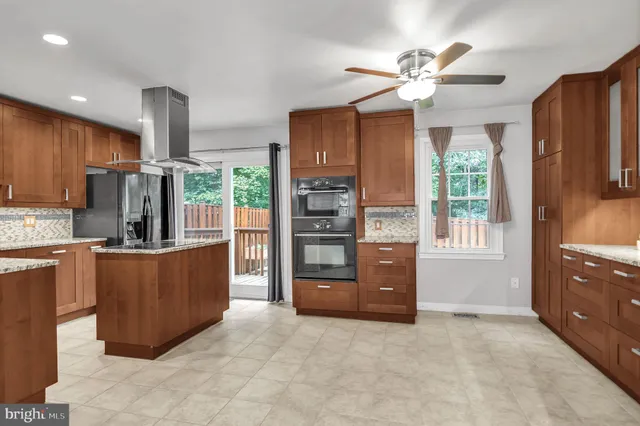 a living room with stainless steel appliances kitchen island granite countertop furniture and a large window
