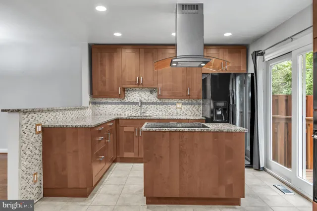 a kitchen with stainless steel appliances granite countertop a refrigerator a sink and a stove