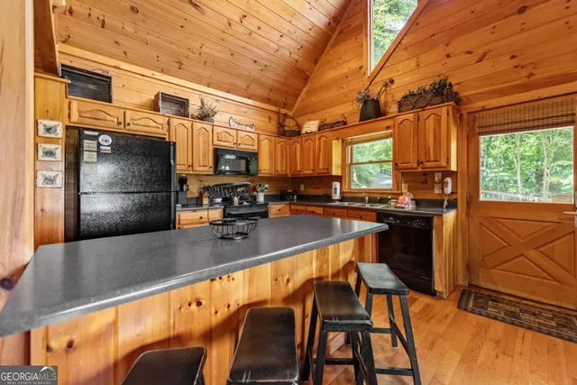 a bedroom with a bed a chandelier and next to a window