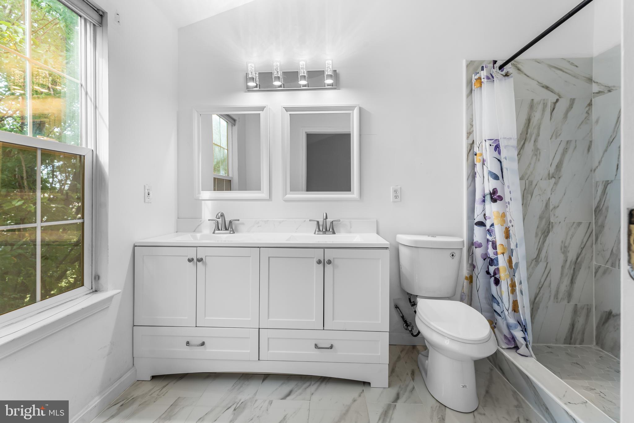 9443 Fields Road Gaithersburg, MD 20878 - Photo 22 of 27 a bathroom with a sink a toilet and shower