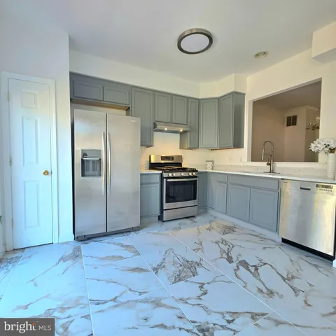 a kitchen with stainless steel appliances granite countertop a stove a sink dishwasher a refrigerator and a microwave oven