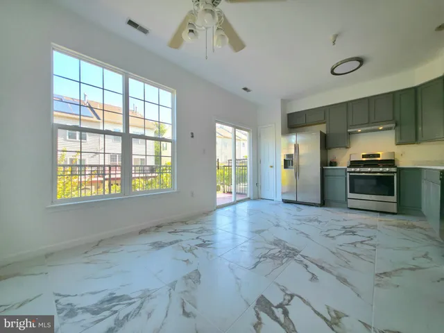 a view of an empty room with a kitchen
