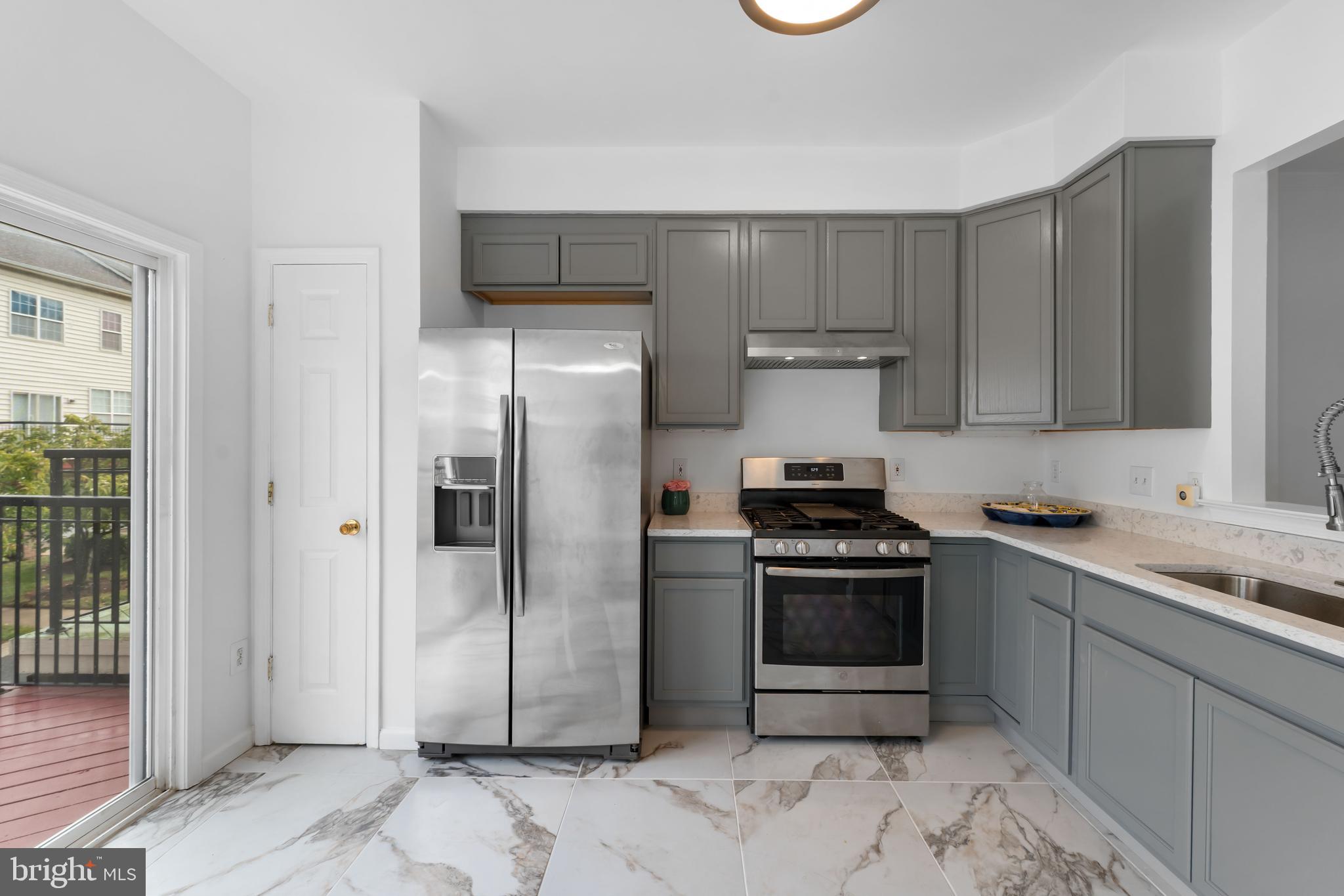 9443 Fields Road Gaithersburg, MD 20878 - Photo 8 of 27 a kitchen with stainless steel appliances granite countertop a stove a refrigerator and a sink