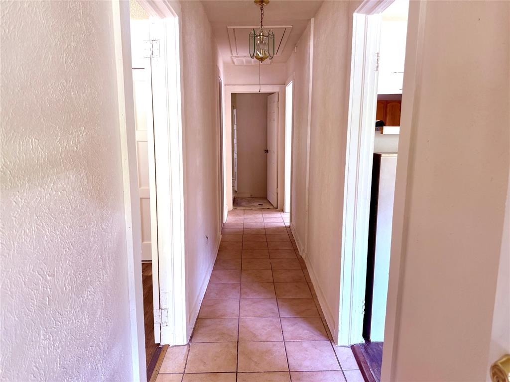 4623 Spring Garden Street Dallas, TX 75215 - Photo 11 of 12 a view of a hallway with wooden floor and a bathroom