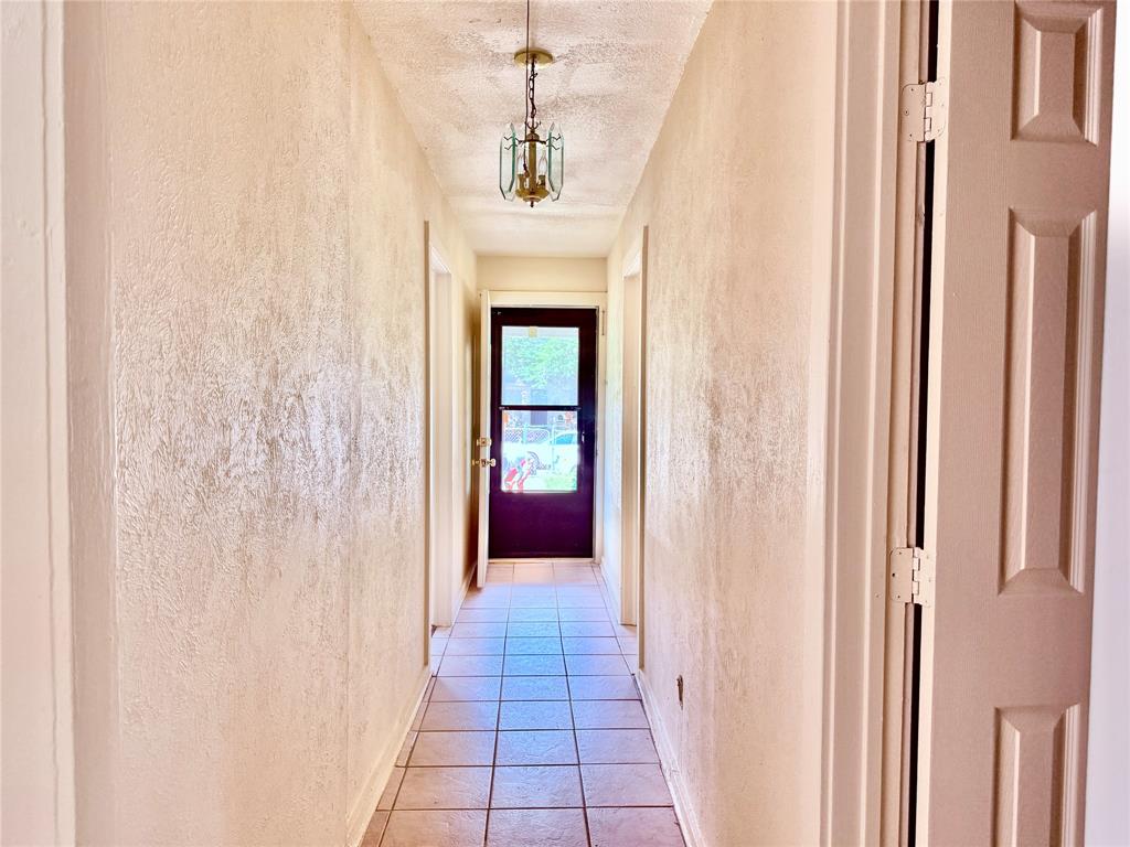 4623 Spring Garden Street Dallas, TX 75215 - Photo 2 of 12 a view of a hallway with wooden floor and staircase