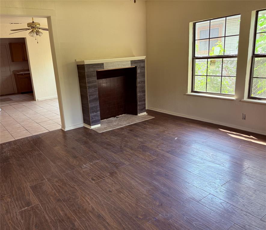 4623 Spring Garden Street Dallas, TX 75215 - Photo 4 of 12 a view of an empty room with wooden floor and a window