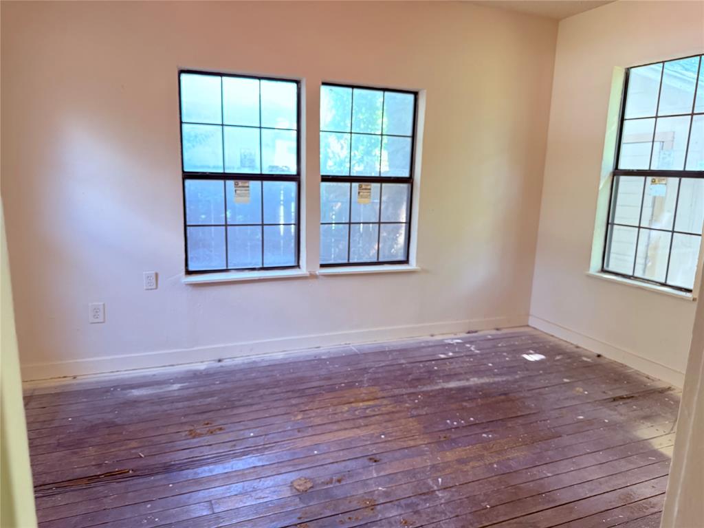 4623 Spring Garden Street Dallas, TX 75215 - Photo 8 of 12 an empty room with wooden floor and windows