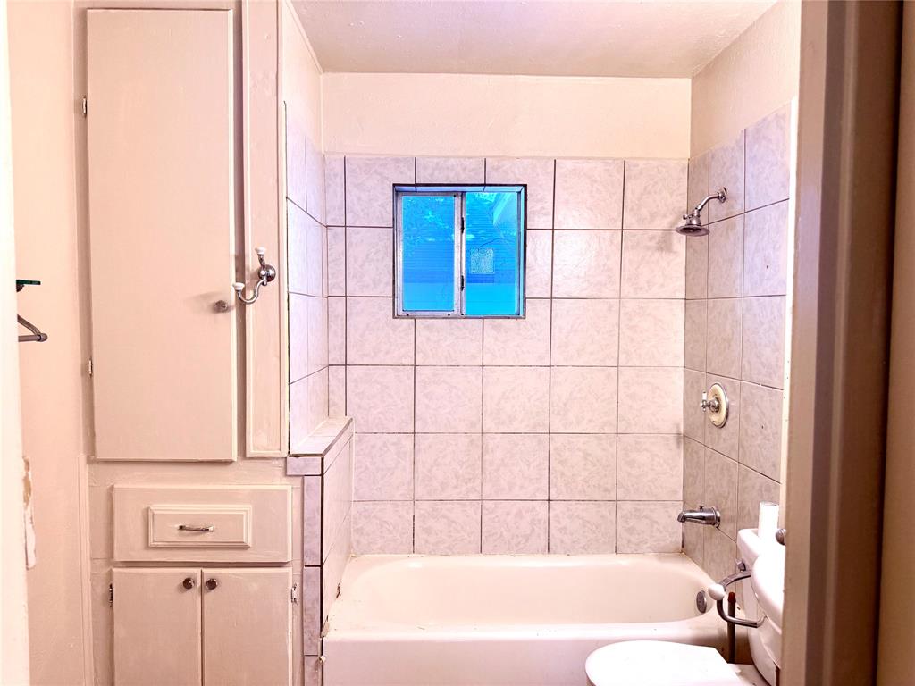 4623 Spring Garden Street Dallas, TX 75215 - Photo 10 of 12 a bathroom with a bathtub and shower