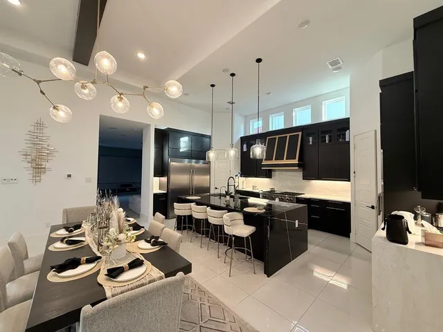 a living room with stainless steel appliances kitchen island granite countertop a stove and a sink