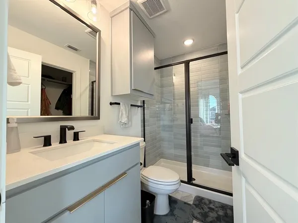 a bathroom with a sink a toilet and shower