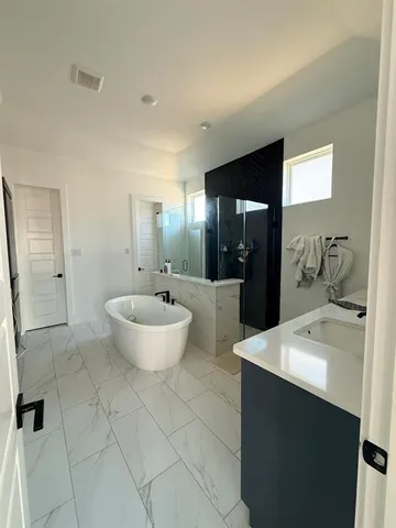 a spacious bathroom with a bathtub sink and mirror