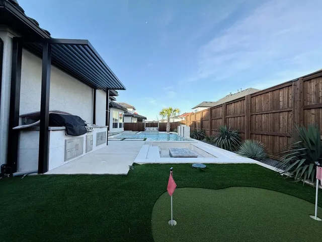 a view of a house with backyard and patio