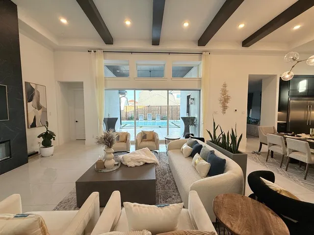 a living room with furniture floor to ceiling window and a flat screen tv