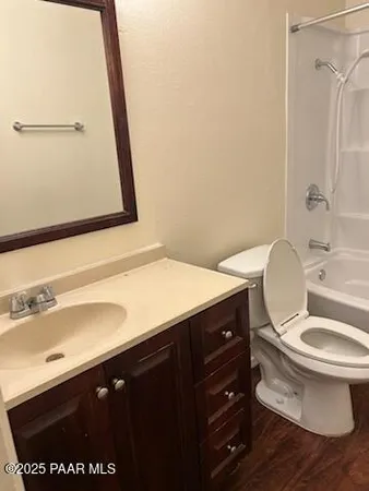a bathroom with a granite countertop toilet sink and mirror