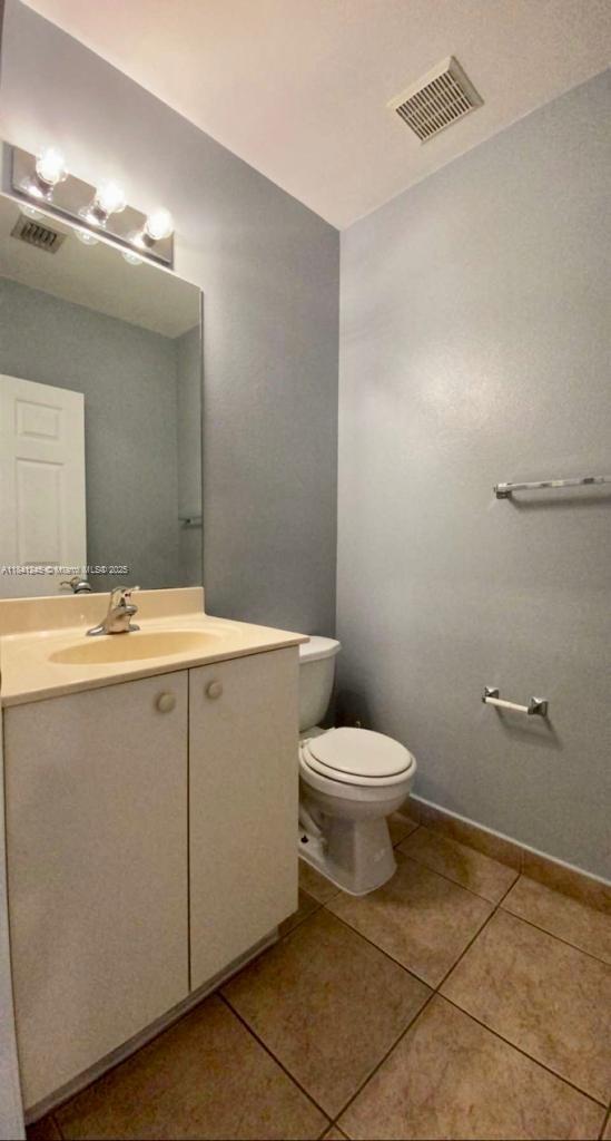 8491 Southwest 27th Street, Unit 101 Miramar, FL 33025 - Photo 2 of 10 a bathroom with a toilet sink and mirror