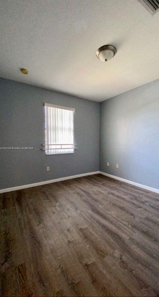 8491 Southwest 27th Street, Unit 101 Miramar, FL 33025 - Photo 5 of 10 an empty room with wooden floor and windows
