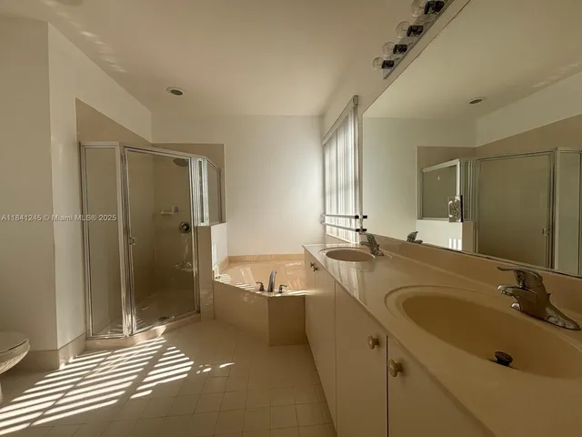 a bathroom with a tub sink and mirror