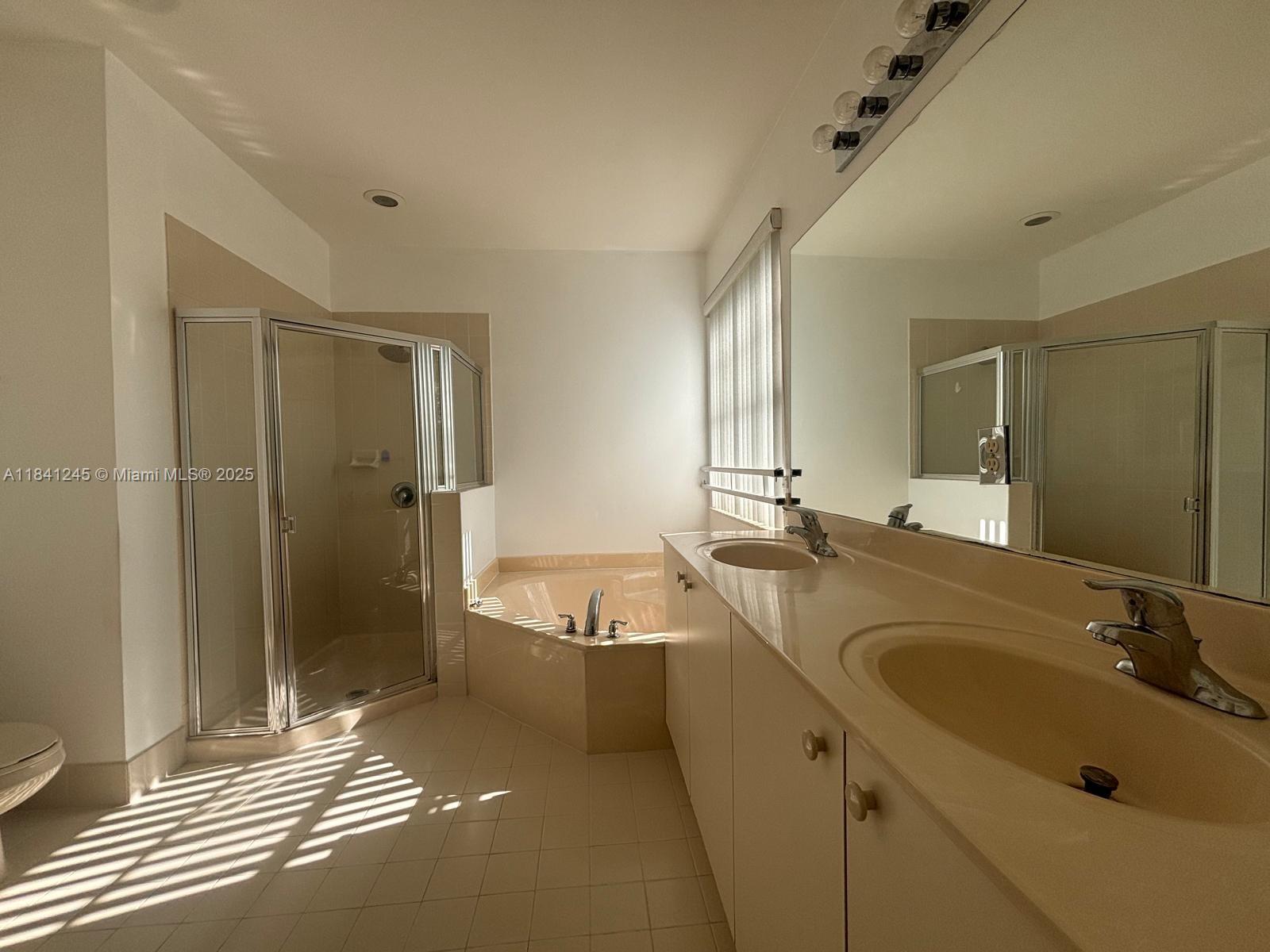 8491 Southwest 27th Street, Unit 101 Miramar, FL 33025 - Photo 7 of 10 a bathroom with a tub sink and mirror