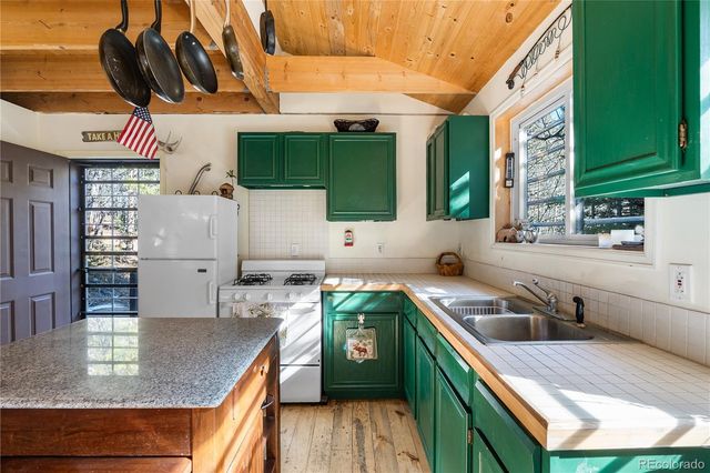 a kitchen with a refrigerator a stove and a sink