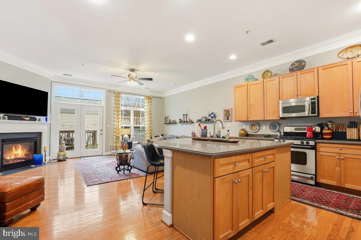 23416 Clarksridge Road Clarksburg, MD 20871 - Photo 7 of 48 a kitchen with stainless steel appliances granite countertop a stove top oven a sink a dining table and chairs with wooden floor