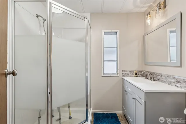 a bathroom with a shower sink vanity and mirror