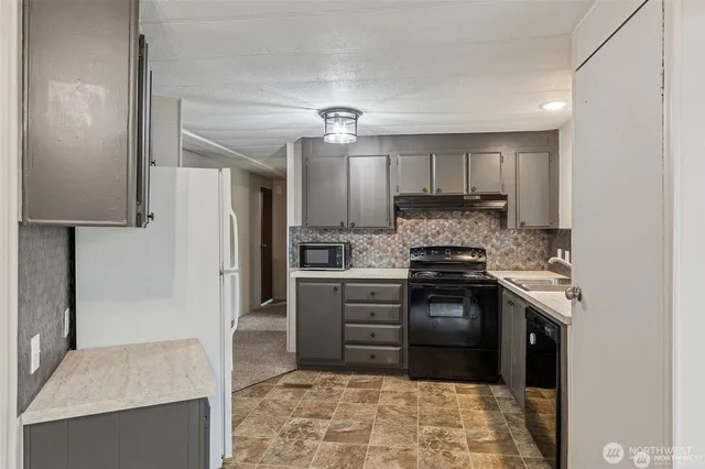 a kitchen with stainless steel appliances granite countertop a stove a refrigerator and a sink
