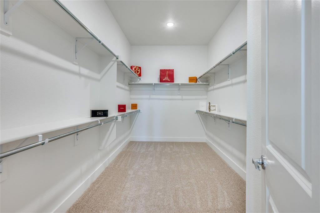 1309 Old Rocksprings Pass Mansfield, TX 76063 - Photo 17 of 36 Walk-in closet featuring extensive built-in shelving and hanging rods, neutral carpet flooring, recessed lighting, and crisp white walls