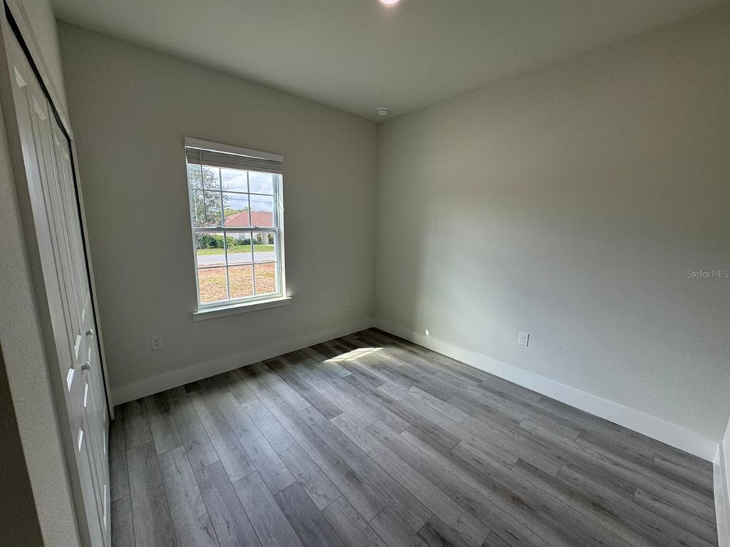 13385 Southwest 32nd Court Ocala, FL 34473 - Photo 11 of 20 an empty room with wooden floor and windows