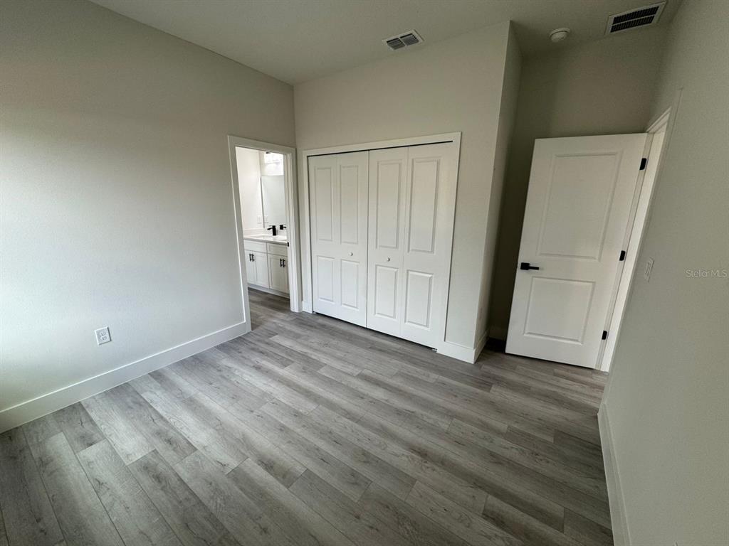 13385 Southwest 32nd Court Ocala, FL 34473 - Photo 12 of 20 an empty room with wooden floor and mirror