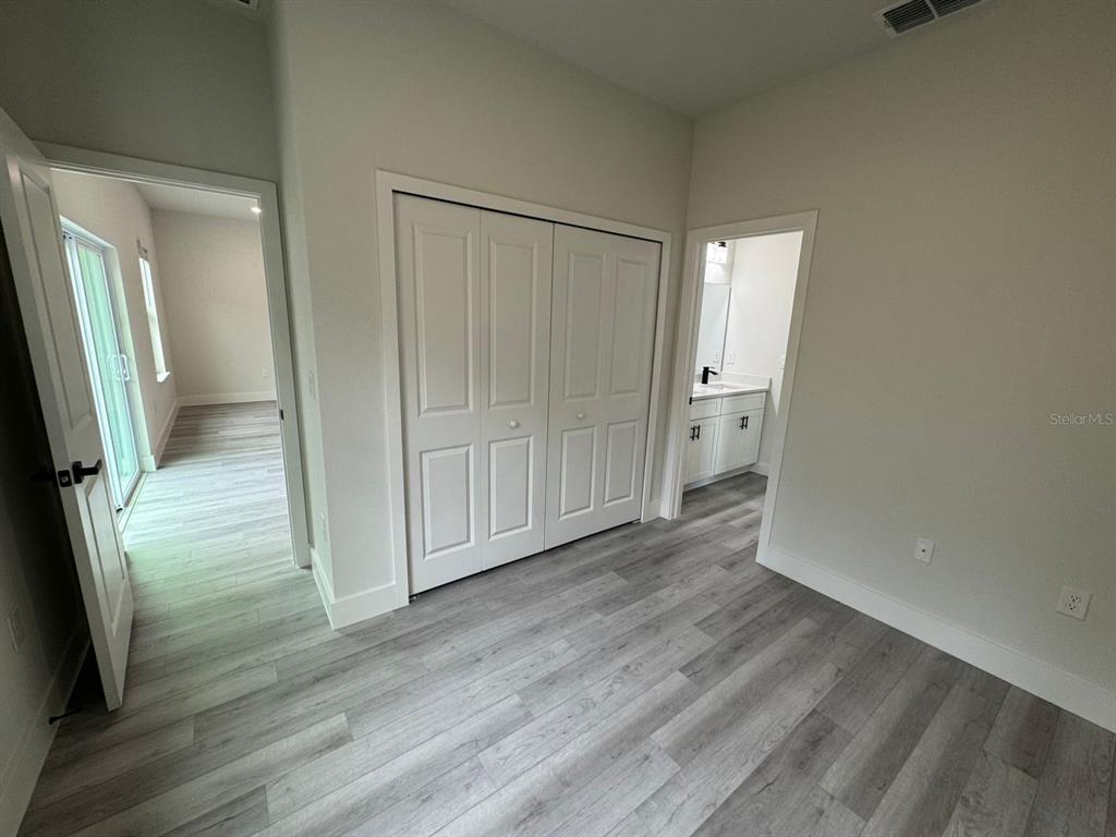13385 Southwest 32nd Court Ocala, FL 34473 - Photo 17 of 20 an empty room with wooden floor and mirror
