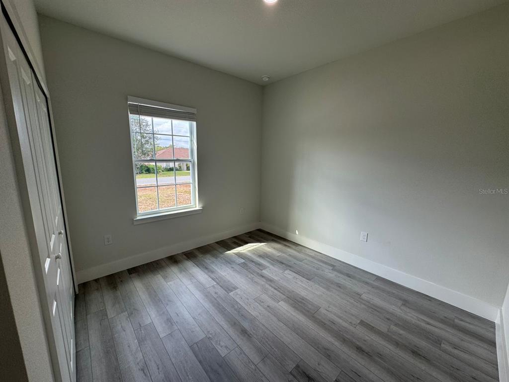13385 Southwest 32nd Court Ocala, FL 34473 - Photo 6 of 20 an empty room with wooden floor and windows