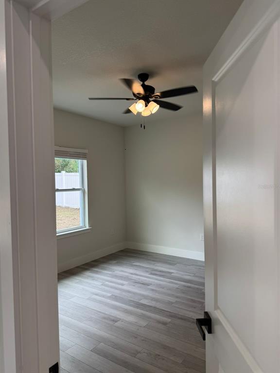 13385 Southwest 32nd Court Ocala, FL 34473 - Photo 10 of 20 a view of empty room with wooden floor and fan