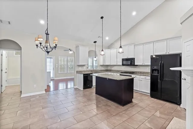 a spacious bathroom with a granite countertop sink a large mirror and a shower