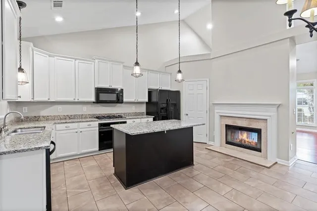 a kitchen with kitchen island a counter space a sink appliances and cabinets