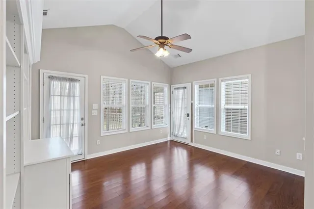 a view of an empty room with a window and wooden floor