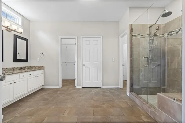 a bathroom with a granite countertop sink mirror and cabinets