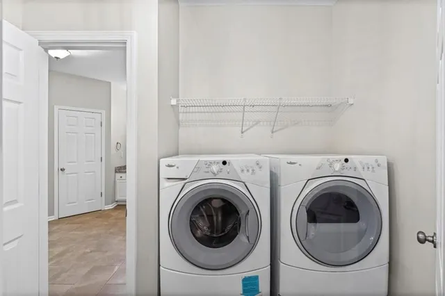 an empty room with wooden floor chandelier and windows