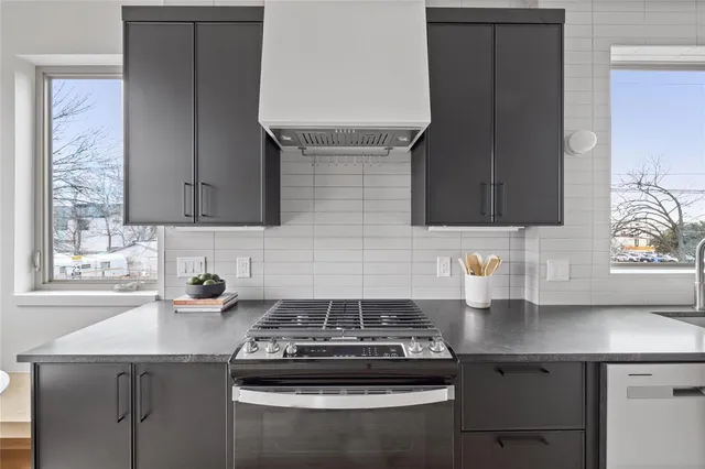 a kitchen with granite countertop a sink a stove and cabinets