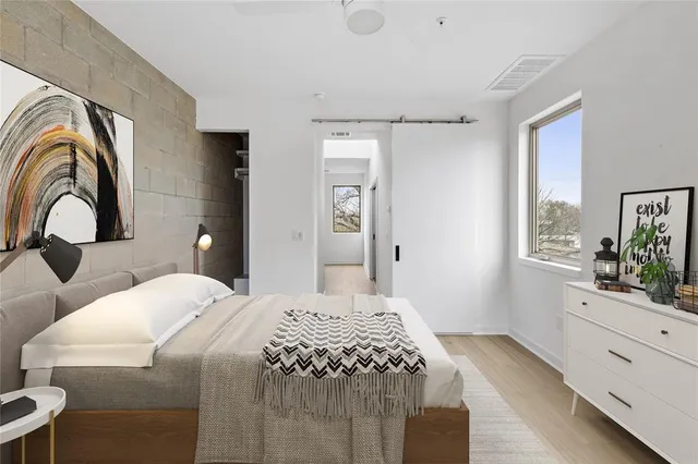 a bedroom with a bed and a dresser with mirror