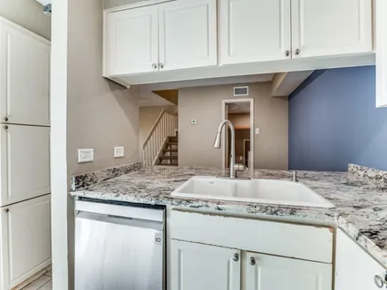 a bathroom with kitchen island granite countertop a sink and cabinets