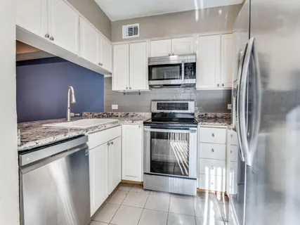 a kitchen with stainless steel appliances granite countertop a refrigerator sink and stove