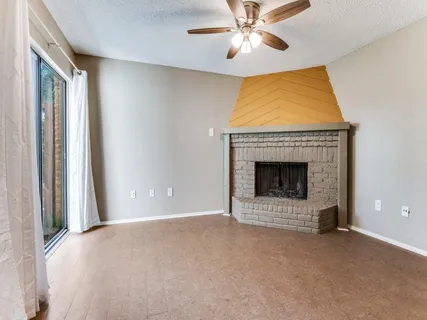 a view of an empty room with a fireplace and a window